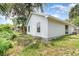 Angle view of the house from the backyard surrounded by mature trees and grass at 779 Victoria E Cir, Ormond Beach, FL 32174