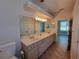 Bright bathroom features double sinks, large vanity mirror, and ample storage at 821 Wingate Trl, Port Orange, FL 32128