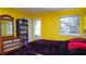 Bedroom with yellow walls, full bed, and built-in shelving at 855 E Church St, Deland, FL 32724