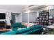 Living room with teal sectional sofa, large windows, and extensive media collection at 855 E Church St, Deland, FL 32724