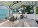 Covered outdoor patio with a dining set and grill, perfect for entertaining, set against a white privacy fence at 1146 Riverside Dr, Daytona Beach, FL 32117