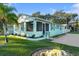 Charming single-story light blue home with a screened porch and well-maintained lawn and landscaping at 1146 Riverside Dr, Daytona Beach, FL 32117