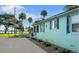 Side view of a charming light blue home with dark blue shutters, showcasing its unique architectural details at 1146 Riverside Dr, Daytona Beach, FL 32117