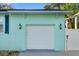 Close-up of a white garage door with decorative lights on a light blue home's exterior at 1146 Riverside Dr, Daytona Beach, FL 32117