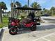 Eye-catching red golf cart with rugged tires and seating for four, ideal for community enjoyment at 1146 Riverside Dr, Daytona Beach, FL 32117