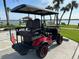 Back view of the red golf cart overlooking waterfront, ready for leisurely rides around the community at 1146 Riverside Dr, Daytona Beach, FL 32117