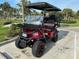 Stylish red golf cart with a functional front rack, perfect for neighborhood adventures and errands at 1146 Riverside Dr, Daytona Beach, FL 32117