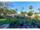 Large backyard with grassy lawn, wooden fence, and various potted plants at 453 Merrimac Dr, Port Orange, FL 32127