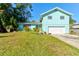 Light teal house with a white garage door and well-maintained lawn at 453 Merrimac Dr, Port Orange, FL 32127
