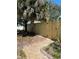 A backyard featuring a new wooden fence, a brick-paved path, and lush tropical landscaping offering privacy and charm at 5178 Riverside Dr, Port Orange, FL 32127