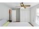 Bedroom with light blue walls, white closet, and ceiling fan at 5178 Riverside Dr, Port Orange, FL 32127