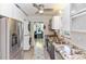 Bright kitchen featuring stainless steel appliances, stacked washer/dryer, and granite countertops at 5178 Riverside Dr, Port Orange, FL 32127