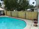 Backyard pool with a wooden fence provides privacy to enjoy the outdoor living space at 5178 Riverside Dr, Port Orange, FL 32127