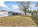 Large backyard with grassy area, mature tree, and privacy fence at 1275 Elkcam Blvd, Deltona, FL 32725