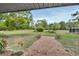 Brick pathway leading to a spacious backyard with greenery at 180 Robinson Ln, Seville, FL 32190