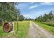 Gravel driveway leading to the property with a rustic wheel at 180 Robinson Ln, Seville, FL 32190