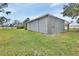 Metal storage building with sliding doors, located in a grassy area at 180 Robinson Ln, Seville, FL 32190