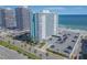 An aerial view of a beachfront condo building, palm trees, and an ocean view at 2800 N Atlantic Ave # 212, Daytona Beach, FL 32118
