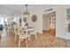 A dining room with a mirrored wall, wood floors, white table and chairs, and views to other rooms at 2800 N Atlantic Ave # 212, Daytona Beach, FL 32118