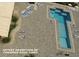 Aerial view of a T-shaped pool featuring fire pits, lounge chairs, tables, and stone flooring at 2800 N Atlantic Ave # 212, Daytona Beach, FL 32118