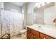 Neutral toned bathroom featuring a shower with floral curtain and a wood vanity with white sink at 430 Cypress Hills Way, Deland, FL 32724