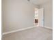 This empty bedroom has neutral walls, white trim, and a door that leads to a glimpse of a kitchen at 430 Cypress Hills Way, Deland, FL 32724