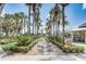 Community grounds with a landscaped walkway leading to a covered outdoor seating area surrounded by palm trees at 430 Cypress Hills Way, Deland, FL 32724