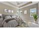 Comfortable main bedroom with a decorative rug, tray ceiling, and sun-filled windows at 430 Cypress Hills Way, Deland, FL 32724