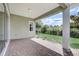 Covered patio features brick pavers, a large support beam, and a view of the green landscape and fence at 430 Cypress Hills Way, Deland, FL 32724