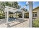Community pool area with a small pool, pergola, chairs, and a lush green landscape at 430 Cypress Hills Way, Deland, FL 32724