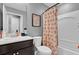 Cozy bathroom features a vanity with modern faucet, toilet, shower and tub combo with colorful rainbow-themed shower curtain at 635 Belgrove St, Debary, FL 32713