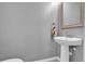 Powder room featuring a pedestal sink, decorative mirror and towel, and neutral gray walls at 635 Belgrove St, Debary, FL 32713