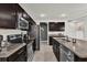 Modern kitchen featuring dark cabinetry, stainless steel appliances, and granite countertops at 635 Belgrove St, Debary, FL 32713