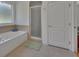 Bright bathroom featuring a soaking tub and a separate glass-enclosed shower at 955 N Ridgewood Ave, Deland, FL 32720