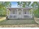 Charming cottage with a cozy porch and white railing perfect for relaxing at 955 N Ridgewood Ave, Deland, FL 32720