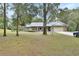 Inviting home with stone accents, a spacious two-car garage, and mature trees at 955 N Ridgewood Ave, Deland, FL 32720