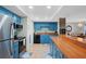 Modern kitchen with blue cabinets, wood countertops, and stainless steel appliances at 1513 Ocean Shore Blvd # 2B, Ormond Beach, FL 32176