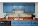 Kitchen features blue cabinets, wood countertops, and a double sink at 1513 Ocean Shore Blvd # 2B, Ormond Beach, FL 32176