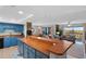 Open kitchen with blue cabinets and long wood countertop at 1513 Ocean Shore Blvd # 2B, Ormond Beach, FL 32176