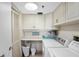 Bright laundry room with washer, dryer, and built-in cabinets at 1513 Ocean Shore Blvd # 2B, Ormond Beach, FL 32176