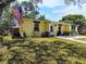 Charming single-story home featuring a well-manicured lawn and stone-accented facade and an American Flag at 1649 W Waycross Cir, Deltona, FL 32725