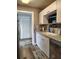 Kitchen features white cabinets, stainless steel appliances, and updated flooring at 1649 W Waycross Cir, Deltona, FL 32725