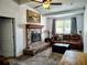 Inviting living room featuring a stone fireplace, ceiling fan and plush sofa at 1649 W Waycross Cir, Deltona, FL 32725