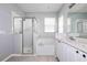 Bright bathroom featuring a glass enclosed shower, soaking tub, and a double sink vanity at 189 Perfect Dr, Daytona Beach, FL 32124