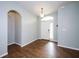 Inviting foyer with wood-look tile flooring, arched doorway, and a bright front door with sidelight at 189 Perfect Dr, Daytona Beach, FL 32124