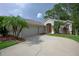 Inviting home featuring a two-car garage, landscaped yard, and elegant entryway with arched alcove at 189 Perfect Dr, Daytona Beach, FL 32124