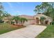 Tan house with palm trees, a two-car garage, and a manicured lawn at 189 Perfect Dr, Daytona Beach, FL 32124