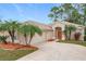 Tan house with palm trees, a two-car garage, and a manicured lawn at 189 Perfect Dr, Daytona Beach, FL 32124