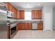 Well-lit kitchen featuring stainless steel appliances, tile floors, and wooden cabinetry at 189 Perfect Dr, Daytona Beach, FL 32124