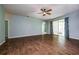 Spacious living room featuring tile floors, a ceiling fan, and sliding glass doors with curtains at 189 Perfect Dr, Daytona Beach, FL 32124